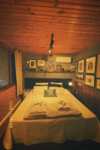 a bedroom with a large bed with a wooden ceiling at Casinha do Fotógrafo em Domingos Martins a 7km do Centro in Domingos Martins