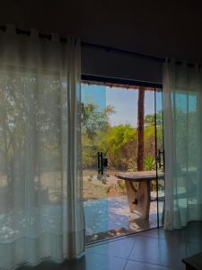 ein Zimmer mit einem großen Fenster und einem Tisch im Freien in der Unterkunft Casa Auryá in Alto Paraíso de Goiás