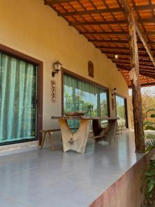eine Veranda mit großem Fenster und Steinboden in der Unterkunft Casa Auryá in Alto Paraíso de Goiás