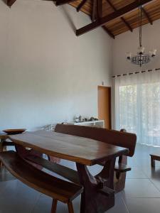 ein Esszimmer mit einem Holztisch und einem Fenster in der Unterkunft Casa Auryá in Alto Paraíso de Goiás + 16 Fotos