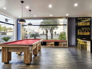 a billiard room with a pool table and a sign at ibis Taubate in Taubaté