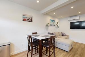 Una sala de estar con una mesa y sillas y un sofá. en Fair Weather, en Newport Heights