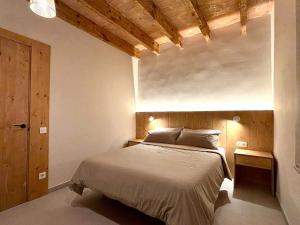 a bedroom with a bed and a wooden ceiling at La Plana allotjament rural in Aviá