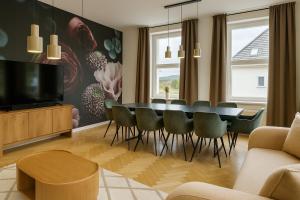 a living room with a dining room table and chairs at Exklusive Fewos - 6 SZ - 14 P - 2 Küchen - 4 Bäder - Mitten in Deutschland - Bahnhof & Altstadt fußläufig in Bad Sooden-Allendorf