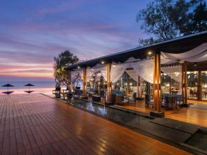 un complejo con terraza con mesas y sillas en V Villas Hua Hin - MGallery Collection, en Hua Hin