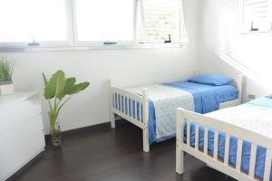a bedroom with two beds and two windows at Zen Retreat City Centre in San Juan