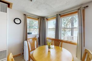 a dining room with a wooden table and two windows at Bayside Sunshine in Freedom +26 photos