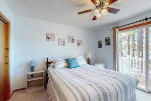 a bedroom with a bed with a ceiling fan and a window at Bayside Sunshine in Freedom