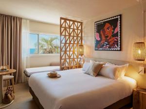 a hotel room with a large white bed and a window at Mercure Saint Raphael Centre Plage in Saint-Raphaël +43 photos