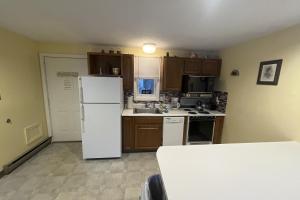 a kitchen with a white refrigerator and wooden cabinets at Misty Harbor Resort - Unit 103 in Dockham Shore
