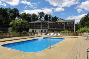 a large house with a swimming pool in front of it at Misty Harbor Resort - Unit 103 in Dockham Shore