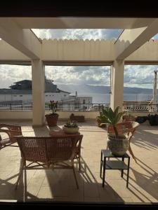 Un patio con sillas y una mesa con plantas en macetas. en Il Moro, en Reggio Calabria