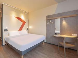 a bedroom with a bed with a red arrow on the wall at Ibis Budget Mont De Marsan in Mont-de-Marsan +47 photos