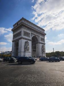 un grand monument avec des voitures garées devant lui dans l'établissement 2 min From Arc de Triomphe Elegant Apartment for 4, à Paris