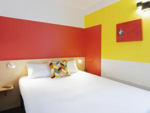 Houdemontにあるgreet Hotel Nancy Sudのカラフルな壁のベッドルーム1室