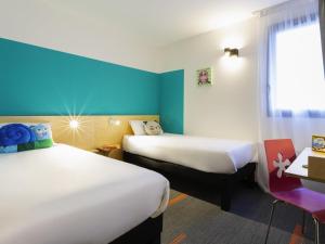 Houdemontにあるgreet Hotel Nancy Sudのベッドが2つと窓があるホテルの部屋