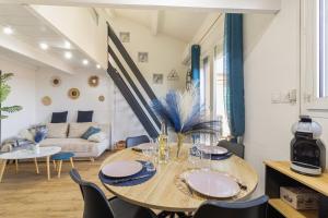 Un comedor con una mesa y un sofá. en T2 MODERNE VUE MER LES SABLETTES CLIM- WiFi- PARKING, en La Seyne-sur-Mer
