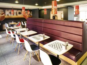 a row of tables and chairs in a restaurant at Ibis London Luton Airport in Luton