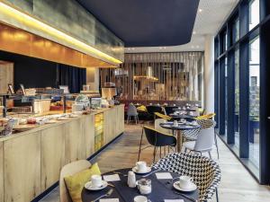 a restaurant with tables and chairs and a counter at MERCURE Hotel Berlin Wittenbergplatz in Berlin