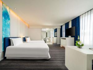 a hotel room with two beds and a television at Grand Mercure Shanghai Century Park- Free Shuttle Bus to SNIEC in Shanghai