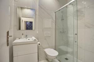 a white bathroom with a toilet and a shower at New Apartment 2 bedrooms center of Paris by Studio prestige in Paris