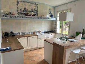 Una cocina con gabinetes blancos y encimera. en Maison Familiale vue mer et plage à pieds, en Ploubazlanec 25 fotos más