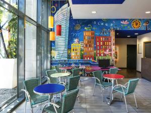a restaurant with tables and chairs and a mural on the wall at Ibis Budget Lyon Centre - Gare Part Dieu in Lyon