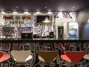 bar z krzesłami i ścianą pokrytą graffiti w obiekcie ibis Recife Aeroporto w mieście Recife