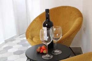 a bottle of wine and two glasses on a table at Suite Alborelli in Alberobello