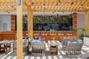 a restaurant with tables and chairs and a bar at The Kimpton Shorebreak Fort Lauderdale Beach Resort in Fort Lauderdale