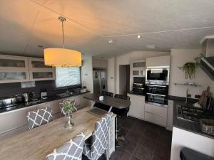 eine Küche und ein Esszimmer mit Tisch und Stühlen in der Unterkunft Skegness retreats The Retreat 20 Golden Palm Resort chapel st leonards in Chapel Saint Leonards + 5 Fotos