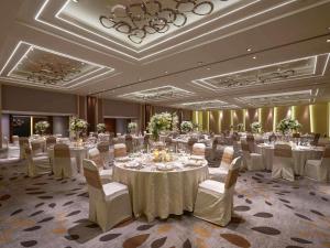 a large banquet room with white tables and chairs at Pullman Jakarta Indonesia in Jakarta +108 photos