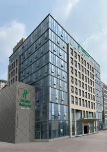 Un edificio alto de cristal con un cartel. en Holiday Inn Jinan Thousand Buddha Mountain by IHG, en Jinan