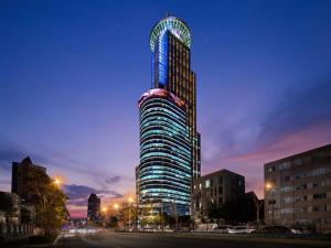 un edificio alto con luces encendidas por la noche en Novotel Atlantis Shanghai, en Shanghái