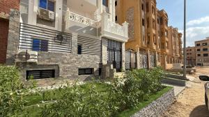 a building with a balcony on the side of a street at Villa from Al Essam Development with private pool, jacuzzi and home cinema المجلس من ال عصام للتطوير مع المسبح والجاكوزي الخاص والهوم سينما in 6th Of October