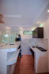 Una cocina blanca con fregadero y encimera. en Maravida Boutique Hotel & Resort, en Tamarindo