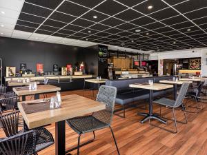 a restaurant with tables and chairs and a counter at ibis Dijon Sud in Perrigny-lès-Dijon
