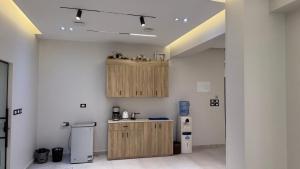 a kitchen with wooden cabinets in a room at Villa from Al Essam Development with private pool, jacuzzi and home cinema المجلس من ال عصام للتطوير مع المسبح والجاكوزي الخاص والهوم سينما in 6th Of October