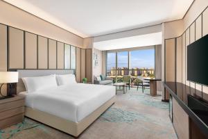 a bedroom with a bed and a flat screen tv at Holiday Inn Shanghai Minhang Center by IHG in Shanghai