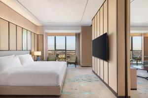 a hotel room with a bed and a tv at Holiday Inn Shanghai Minhang Center by IHG in Shanghai