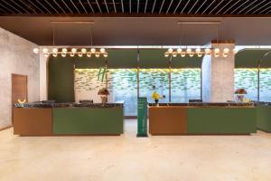 a lobby with green and brown counters and windows at Holiday Inn Shanghai Minhang Center by IHG in Shanghai