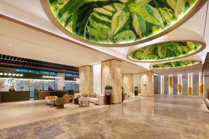 a lobby with a large ceiling with green leaves at Holiday Inn Shanghai Minhang Center by IHG in Shanghai +25 photos