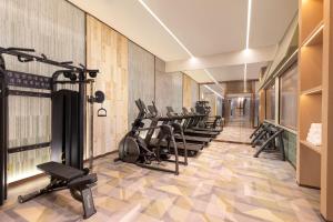 a gym with a row of treadmills and ellipticals at Holiday Inn Shanghai Minhang Center by IHG in Shanghai