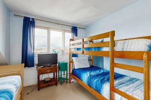 Un dormitorio con dos literas y un televisor. en Beachfront Memories, en Old Orchard Beach
