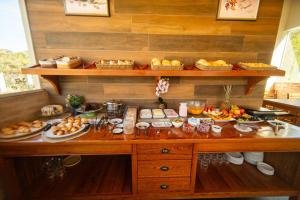 a buffet with many different types of food on it at Chalés Estilo de Campos in Campos do Jordão