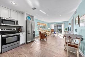 a kitchen with stainless steel appliances and a living room at Sand Dollar Suite - 632A in Siesta Key