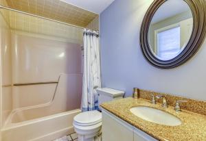 a bathroom with a sink and a toilet and a mirror at Scouten Beachfront in Old Orchard Beach +16 photos