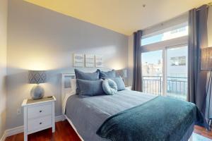 a bedroom with a bed with blue pillows and a window at Belltown Escape in Seattle +23 photos