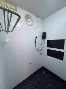 Una habitación con un teléfono en una pared blanca. en Diva house, en Chiang Mai