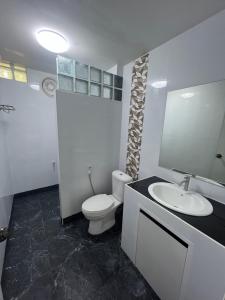 Un baño con un inodoro blanco y un lavabo. en Diva house, en Chiang Mai